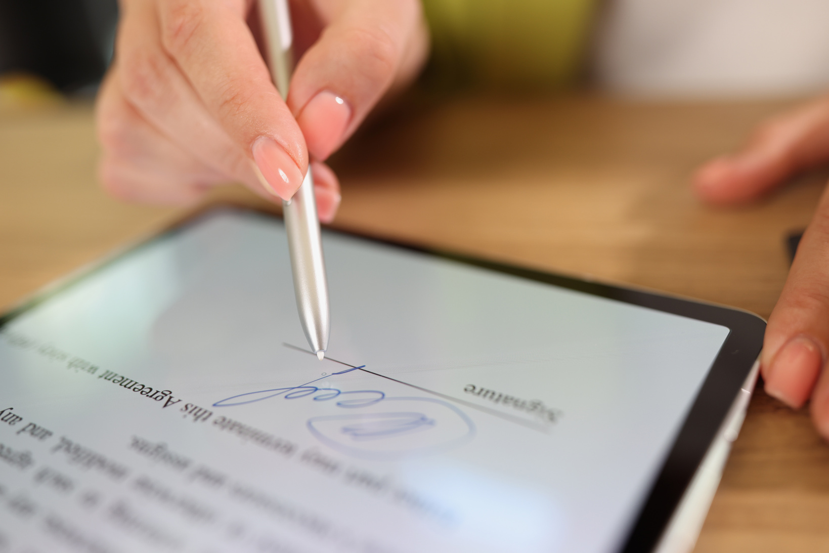 Female Hand Signing E-Document on Tablet with Stylus